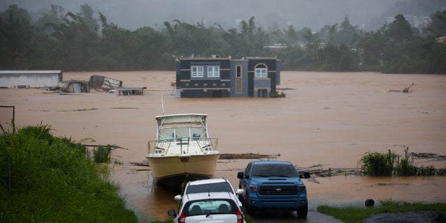 A home is submerged in floodwaters caused by Hurricane Fiona in Cayey, Puerto Rico, Sunday, Sept. 18, 2022.  According to authorities three people were inside the home and were reported to have been rescued.