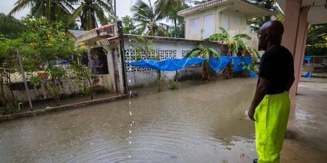 Un lavoratore del comune di Loiza invita i residenti a evacuare a causa delle imminenti inondazioni dovute alle piogge dell'uragano Fiona, a Loiza, Porto Rico, domenica 18 settembre 2022.
