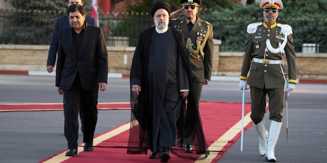 Iranian President Ebrahim Raisi (center) reviews the honor guard during the official departure ceremony for Tehran's Mehrabad airport for New York to attend the annual UN General Assembly on Monday, Sept. 19, 2022. .  (AP Photo/Vahid Salemi)