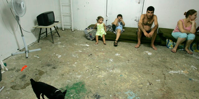An Israeli family sits in a bomb shelter as a rocket warning siren sounds in the northern Israel town of Akko, on Aug. 12, 2006. On Tuesday, Sept. 20, 2022, a U.S. court ordered the Lebanese militant group Hezbollah to pay $111 million in damages to a group of Americans who sued saying they were wounded by the group's rockets during a war with Israel in 2006.