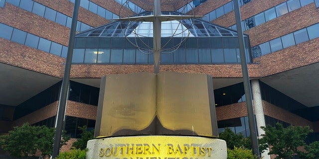 A cross and Bible sculpture stand outside the Southern Baptist Convention