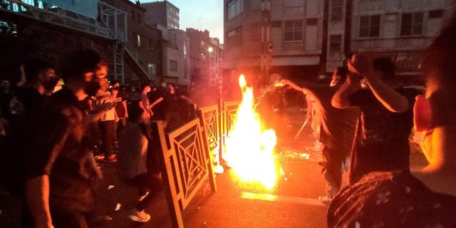 Protesters catch fire and block the street during a protest over the death of a woman who was arrested by the moral police in central Tehran, Iran.  (Photo AP)