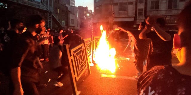 Protesters catch fire and block the street during a protest over the death of a woman who was arrested by the moral police in central Tehran, Iran.  (Photo AP)