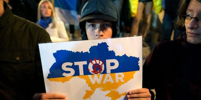 A boy holds a sign during a protest in Belgrade, Serbia, Sept. 21, 2022, against the mobilization announced by Russian President Vladimir Putin.