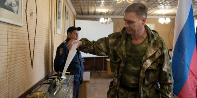 A Luhansk People's Republic serviceman votes in a polling station in Luhansk, Luhansk People's Republic, controlled by Russia-backed separatists, eastern Ukraine, Friday, Sept. 23, 2022. Voting began Friday in four Moscow-held regions of Ukraine on referendums to become part of Russia. 