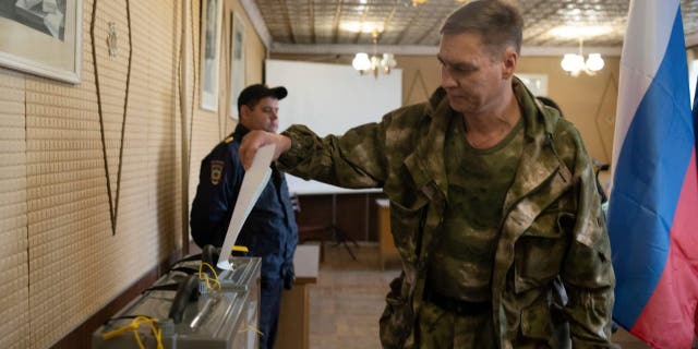 A Luhansk People's Republic serviceman votes in a polling station in Luhansk, Luhansk People's Republic, controlled by Russia-backed separatists, eastern Ukraine, Friday, Sept. 23, 2022. 