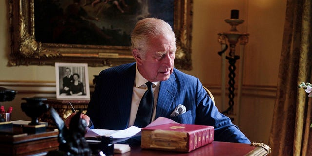 En esta foto del 11 de septiembre de 2022, el rey Carlos III de Gran Bretaña realiza negocios oficiales del gobierno desde su palco rojo en el salón del siglo XVIII en el Palacio de Buckingham en Londres.  (Victoria Jones/PA vía AP)