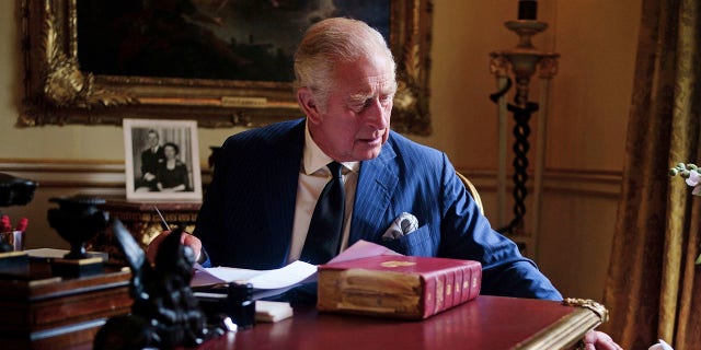 In this photo taken on September 11, 2022, Britain's King Charles III performs official government duties from his red box in the Eighteenth Century Room at Buckingham Palace, London.  (Victoria Jones/PA via AP)