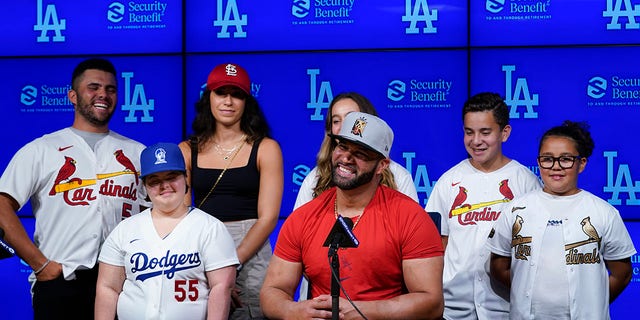 St. Louis Cardinals designated hitter Albert Pujols, center, is surrounded by his family while speaking to reporters after a baseball game against the Los Angeles Dodgers in Los Angeles, Friday, Sept. 23, 2022. Pujols hit his 700th home run during the fourth inning. 