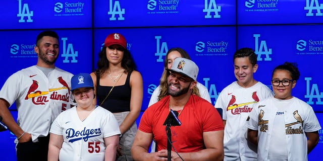 St. Louis Cardinals designated hitter Albert Pujols, center, is surrounded by his family while speaking to reporters after a baseball game against the Los Angeles Dodgers in Los Angeles, Friday, Sept. 23, 2022. Pujols hit his 700th home run during the fourth inning. 