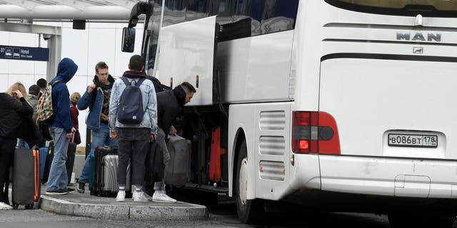 Passengers get off a coach from St. Petersburg, Russia, at the Helsinki Airport in Vantaa, Finland, Saturday Sept. 24, 2022. Finland border guards said Friday that the number of people entering from Russia has climbed sharply, with media reporting a 107% increase compared with last week. 