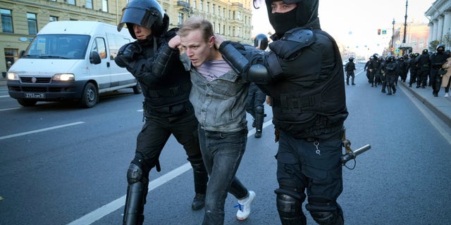 Russian policemen detain a demonstrator protesting against mobilization in St. Petersburg, Russia, Saturday, Sept. 24, 2022.