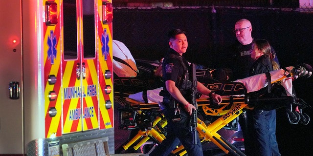 A law enforcement officer walks past an EMS crew on the scene at Kennywood Park, an amusement park in West Mifflin, Pa., early Sunday, Sept 25, 2022.