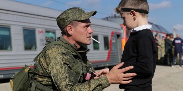 A Russian recruit speaks to his son prior to take a train at a railway station in Prudboi, Volgograd region of Russia, Thursday, Sept. 29, 2022. Russian President Vladimir Putin has ordered a partial mobilization of reservists to beef up his forces in Ukraine.