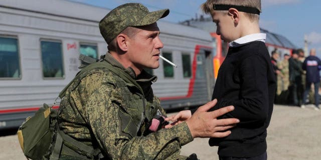 A Russian recruit speaks to his son prior to take a train at a railway station in Prudboi, Volgograd region of Russia, Thursday, Sept. 29, 2022. Russian President Vladimir Putin has ordered a partial mobilization of reservists to beef up his forces in Ukraine.