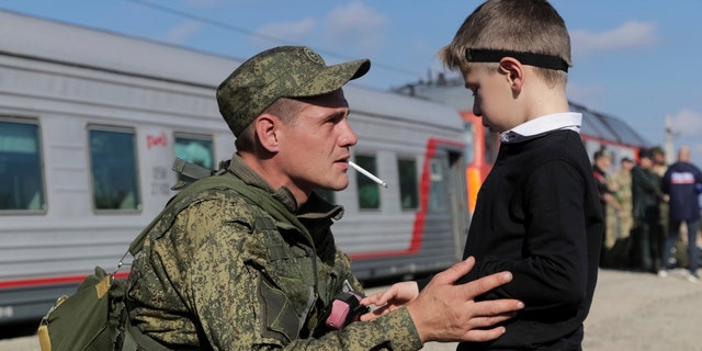 A Russian recruit speaks to his son prior to take a train at a railway station in Prudboi, Volgograd region of Russia, Thursday, Sept. 29, 2022. Russian President Vladimir Putin has ordered a partial mobilization of reservists to beef up his forces in Ukraine. 