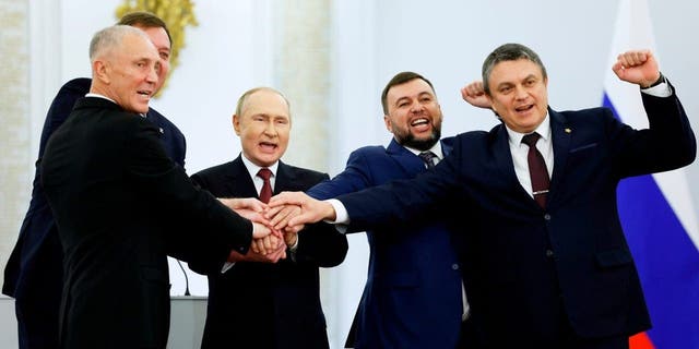 From left, Moscow-appointed head of Kherson Region Vladimir Saldo; Moscow-appointed head of Zaporizhzhia region Yevgeny Balitsky; Russian President Vladimir Putin; Denis Pushilin, leader of self-proclaimed Donetsk People's Republic; and Leonid Pasechnik, leader of self-proclaimed Luhansk People's Republic pose for a photo during a ceremony to sign the treaties for four regions of Ukraine to join Russia at the Kremlin in Moscow on Friday.