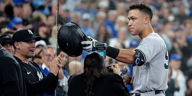 Aaron Judge of the New York Yankees celebrates his 61st home run of the season, a two-run shot against the Toronto Blue Jays, during the seventh inning of a baseball game in Toronto Wednesday, Sept. 28, 2022, and thanks his family. 