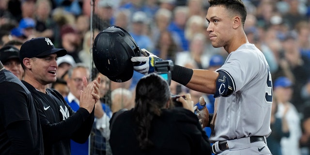 Aaron Judge of the New York Yankees celebrates his 61st home run of the season, a two-run shot against the Toronto Blue Jays, during the seventh inning of a baseball game in Toronto Wednesday, Sept. 28, 2022, and thanks his family. 