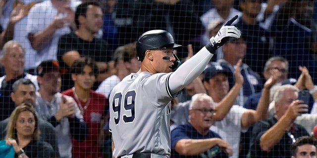 New York Yankees' Aaron Judge, #99, celebrates after scoring on a three-run double by Gleyber Torres during the 10th inning of the team's baseball game against the Boston Red Sox, Tuesday, Sept. 13, 2022, in Boston.