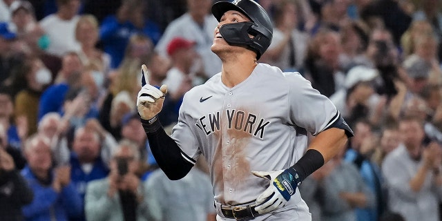 New York Yankees' Aaron Judge celebrates his 61st home run of the season, a two-run homer against the Toronto Blue Jays during the seventh inning, Sept. 28, 2022, in Toronto.