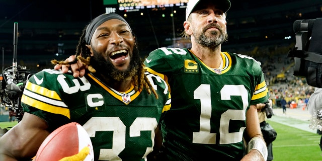 Aaron Jones (#33) walks off the field with teammate quarterback Aaron Rodgers (#12) after an NFL football game against the Chicago Bears on Sept. 18, 2022 in Green Bay, Wisconsin. Green Bay Packers. 