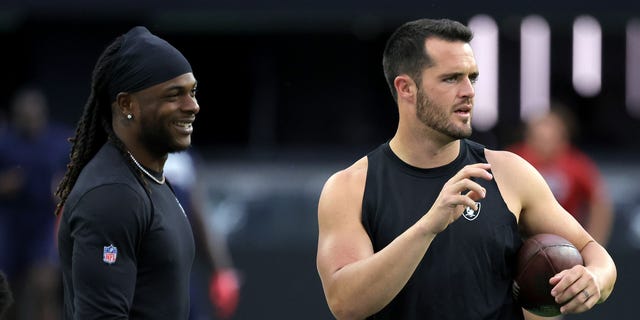 Wide receiver Davante Adams (L) #17 and quarterback Derek Carr #4 of the Las Vegas Raiders talk as they warm up before a preseason game against the New England Patriots at Allegiant Stadium on August 26, 2022, in Las Vegas, Nevada. The Raiders defeated the Patriots 23-6.