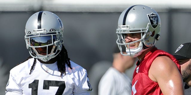 Wide receiver Davante Adams #17 and quarterback Derek Carr #4 of the Las Vegas Raiders talk during training camp at the Las Vegas Raiders Headquarters/Intermountain Healthcare Performance Center on July 24, 2022, in Henderson, Nevada.