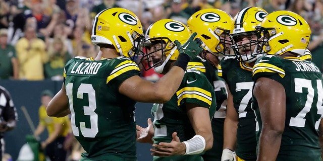 Green Bay Packers wide receiver Allen Lazard, No. 13, celebrates with fellow quarterback Aaron Rodgers, No. 12, after earning a 5-yard touchdown pass during the first half of an NFL football game against the Chicago Bears on Sunday, September 18, 2022, in Green Bay, Wisconsin. 