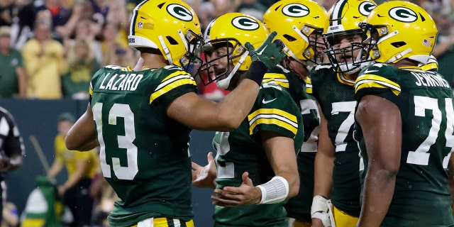 Green Bay Packers wide receiver Allen Lazard, #13, celebrates with teammate quarterback Aaron Rodgers, #12, after catching a 5-yard touchdown pass during the first half of an NFL football game against the Chicago Bears Sunday, Sept. 18, 2022, in Green Bay, Wisconsin.