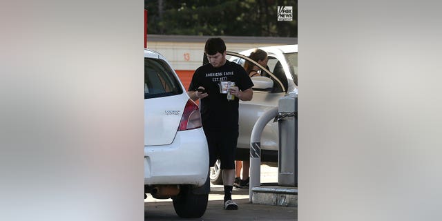 Andrew Giegerich, the boyfriend of murdered Georgia office manager Debbie Collier’s daughter, Amanda Bearden, exits a convenience store with instant noodles and a Mountain Dew Energy drink in hand.