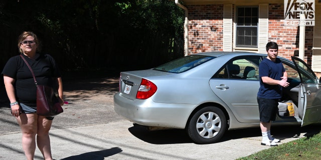 Amanda Bearden and Andrew Giegerich arrive together at her house Friday. Bearden's mother Debbie Collier was found dead under gruesome circumstances off a rural highway earlier this month.