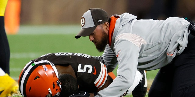 Cleveland Browns linebacker Anthony Walker Jr. (5) is checked by a trainer after being injured during the second half of an NFL football game against the Pittsburgh Steelers in Cleveland, Thursday, Sept. 22, 2022. Walker left the game.