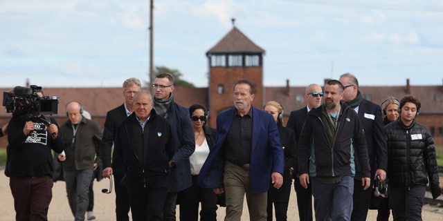 Arnold Schwarzenegger, centrum i Simon Bergson, prezes Fundacji Centrum Żydowskiego w Oświęcimiu, trzeci od lewej, odwiedzają Auschwitz - niemiecki nazistowski obóz śmierci Birkenau 