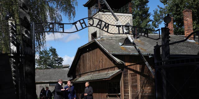 Arnold Schwarzenegger, centrum i Simon Bergson, prezes Fundacji Centrum Żydowskiego w Oświęcimiu, po prawej, odwiedzają niemiecki nazistowski obóz zagłady Auschwitz-Birkenau w Auschwitz, Polska, 