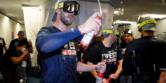 Houston Astros players celebrate in the clubhouse after clinching the American League West title with a win over the Tampa Bay Rays during a baseball game Monday, Sept. 19, 2022, in St. Petersburg, Fla.