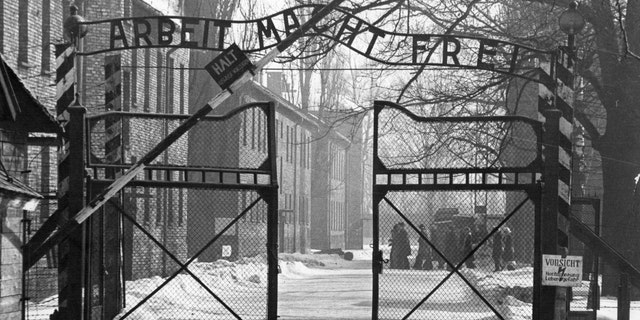 View of the main entrance to the Auschwitz camp. The sign above the gate says "Arbeit Macht Frei" (Work makes one free). Auschwitz, Poland/