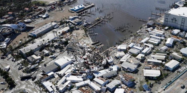 Damaged boats lie on the land and water in the aftermath of Hurricane Ian, Thursday, Sept. 29, 2022, in Fort Myers, Florida. 