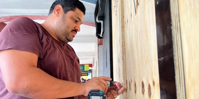A man boards up a store in Hamilton on September 22, 2022.