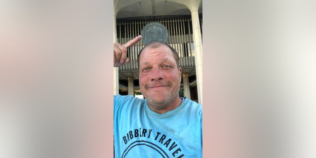 As he has done in every state, Barnes photographed himself in front of the capitol building in Honolulu, Hawaii, on July 25, 2022.