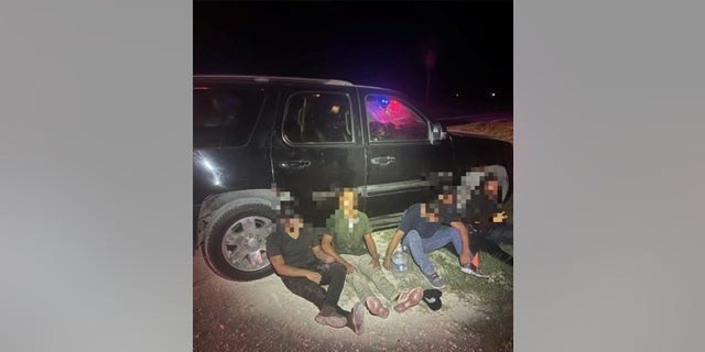 Illegal immigrants apprehended near the Mexican border at night.