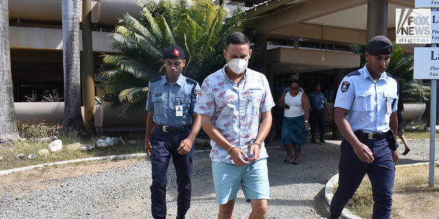 Bradley Dawson in handcuffs is escorted by Fijian police officers back to his cell block after the High Court in Lautoka dismissed his bail application.