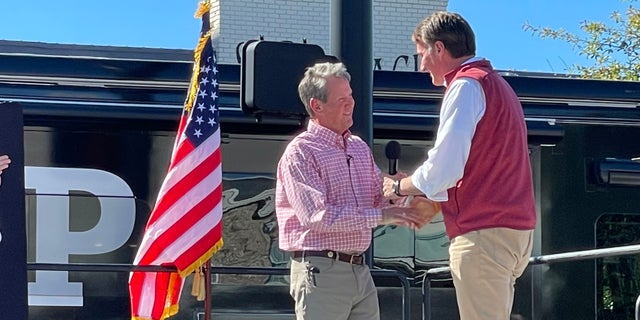 Republican Gov. Glenn Youngkin of Virginia (right) joins GOP Gov. Brian Kemp of Georgia at a Kemp re-election rally on Sept. 27, 2022 in Alpharetta, Georgia