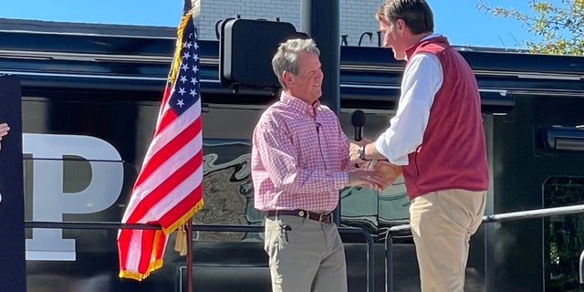 Republican Gov. Glenn Youngkin of Virginia (right) joins GOP Gov. Brian Kemp of Georgia at a Kemp re-election rally on Sept. 27, 2022, in Alpharetta, Georgia