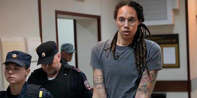 WNBA star and two-time Olympic gold medalist Brittney Griner is escorted from a courtroom after a hearing in Khimki, just outside Moscow, Russia, Aug. 4, 2022. On Thursday, she was freed in exchange for Viktor Bout, a convicted international arms dealer.