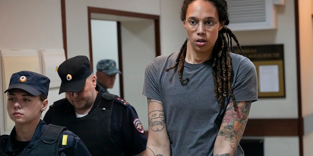 La estrella de la WNBA y dos veces medallista de oro olímpica Brittney Griner es escoltada fuera de la sala del tribunal después de una audiencia, en Khimki, en las afueras de Moscú, Rusia, el 4 de agosto de 2022. 