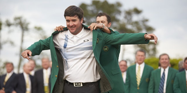 Bubba Watson recibe su chaqueta verde tras ganar en Augusta National.  Ganó el Masters en 2012 y 2014.