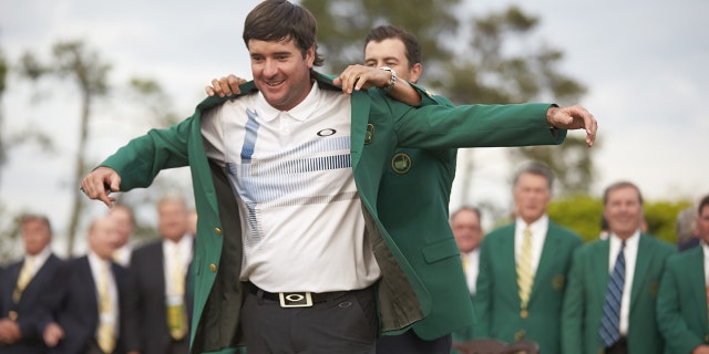 Bubba Watson recibe su chaqueta verde tras ganar en Augusta National.  Ganó el Masters en 2012 y 2014.