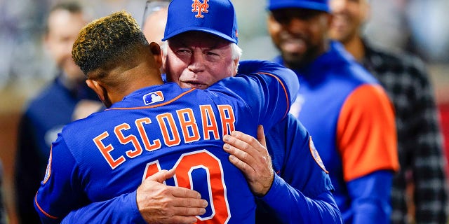 New York Mets manager Buck Showalter, right, hugs New York Mets' Eduardo Escobar after a baseball game against the Miami Marlins Wednesday, Sept. 28, 2022, in New York. The Mets won 5-4.