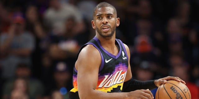 Phoenix Suns'ın 3 numaralı oyuncusu Chris Paul, 15 Mayıs 2022'de Phoenix'te Footprint Center'da Batı Konferansı İkinci Tur NBA Playofflarının Yedinci Maçının ilk yarısında topa dokunuyor.